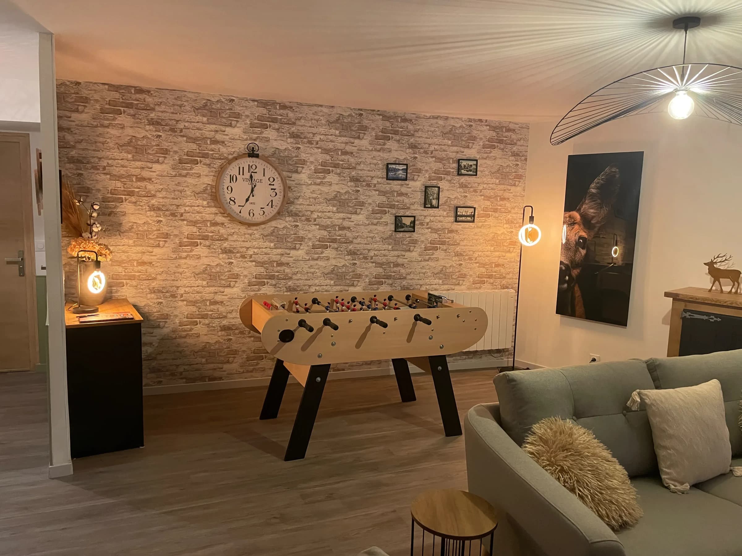Salon, baby-foot devant le mur de briques
