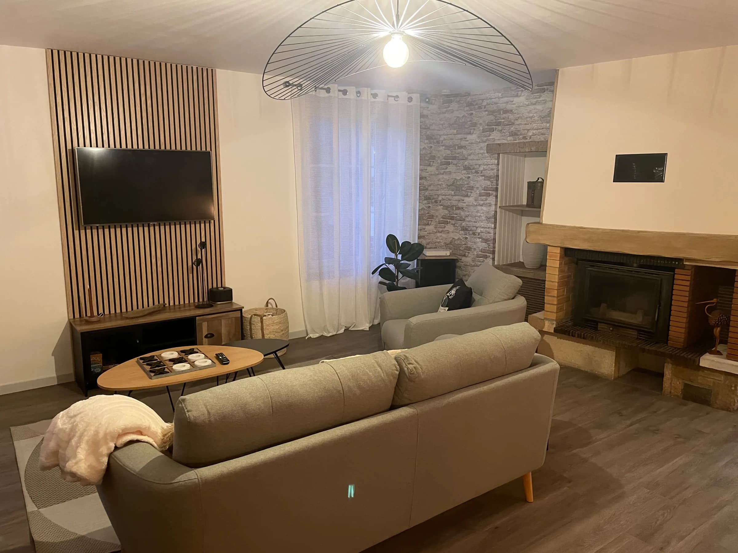 Salon avec cheminée, canapés et télévision