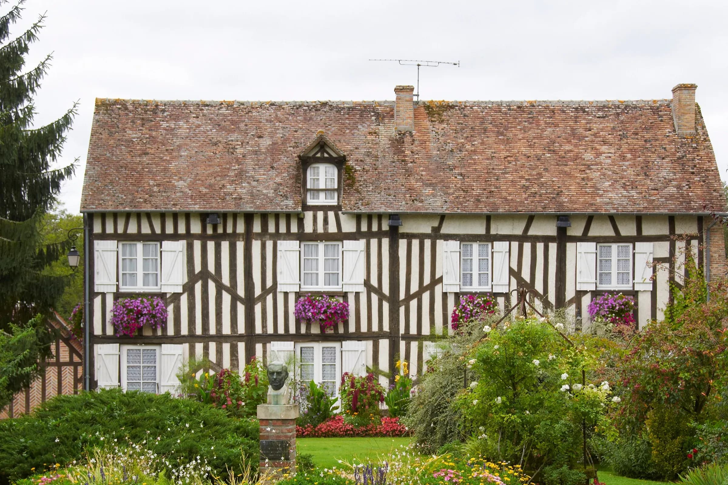 Maison à colombages de Souvigny-en-Sologne, jardinières fleuries et massifs en été