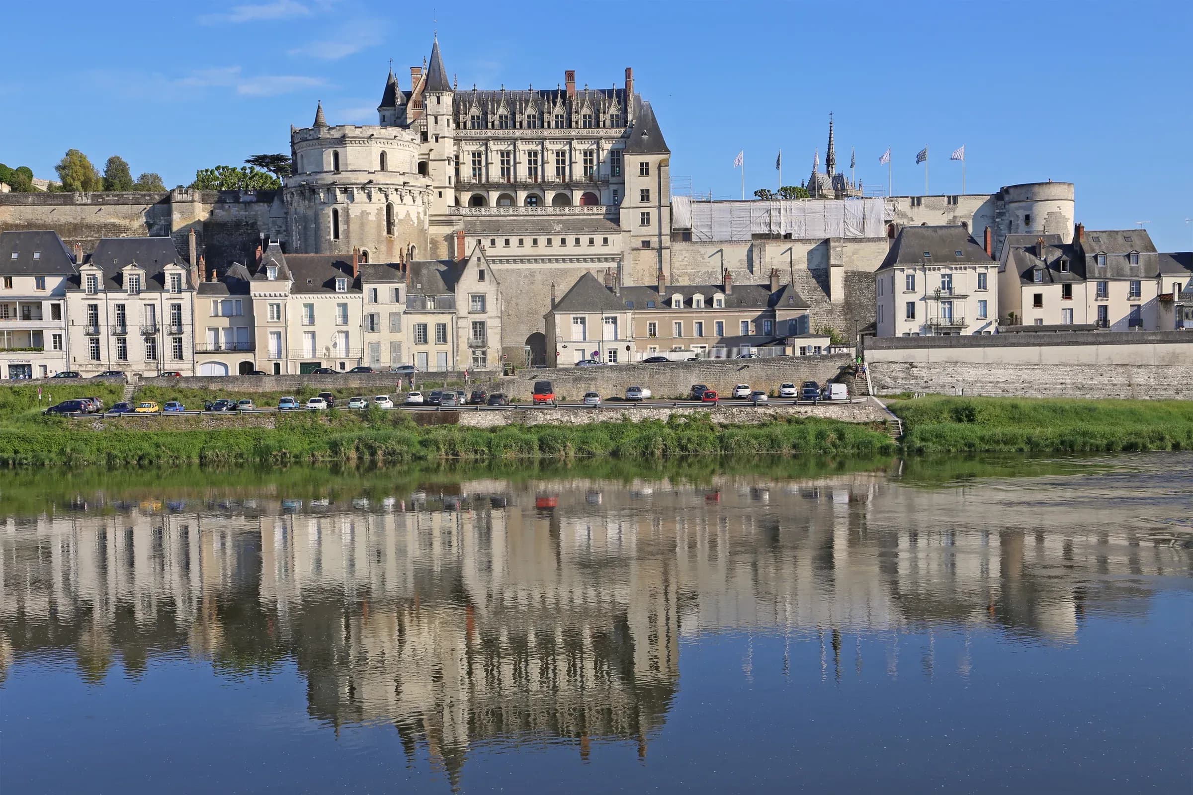 Château royal d'Amboise dominant la ville, reflété dans la Loire sous un ciel bleu