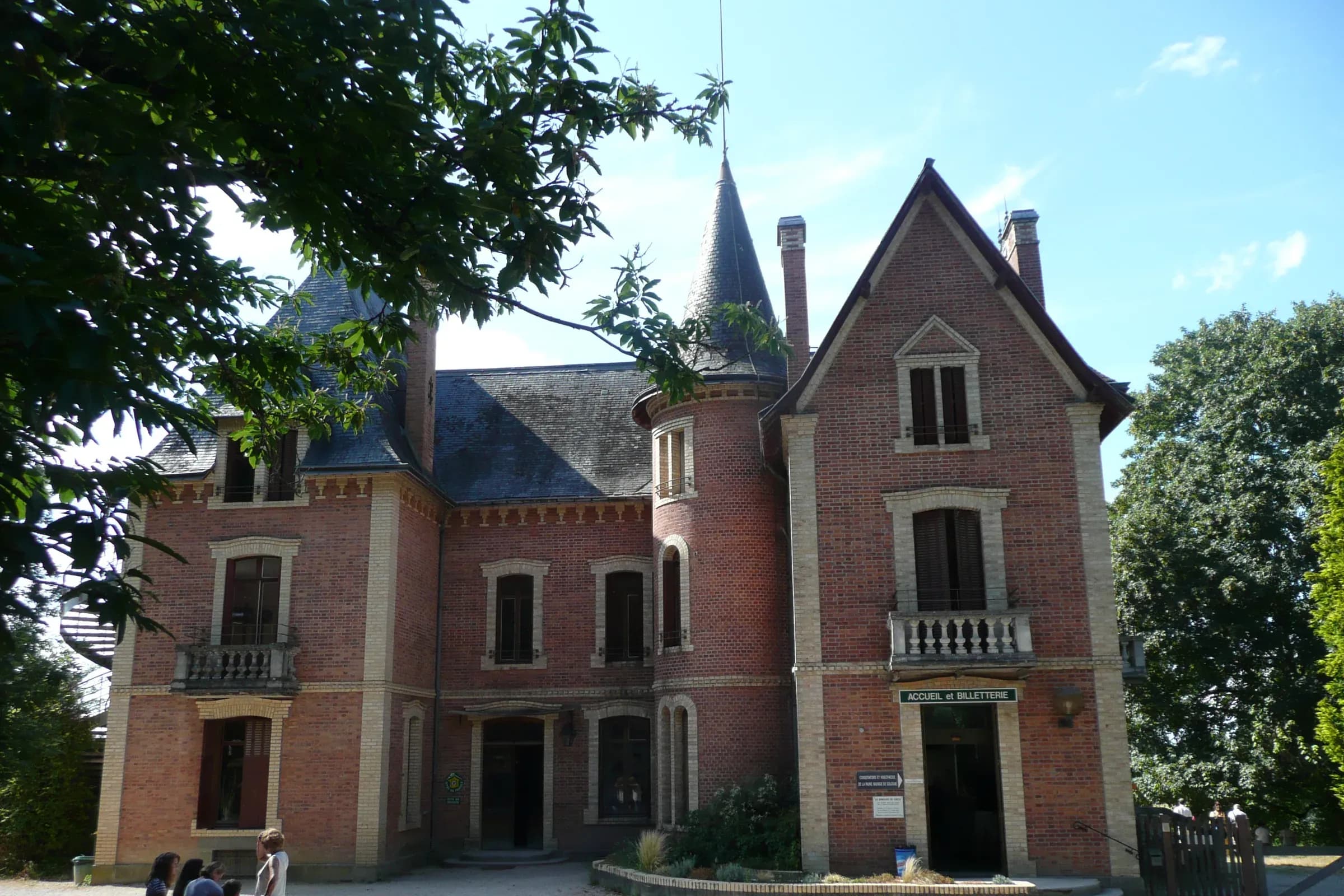 Château de brique du domaine du Ciran à Ménestreau-en-Villette, sous les arbres