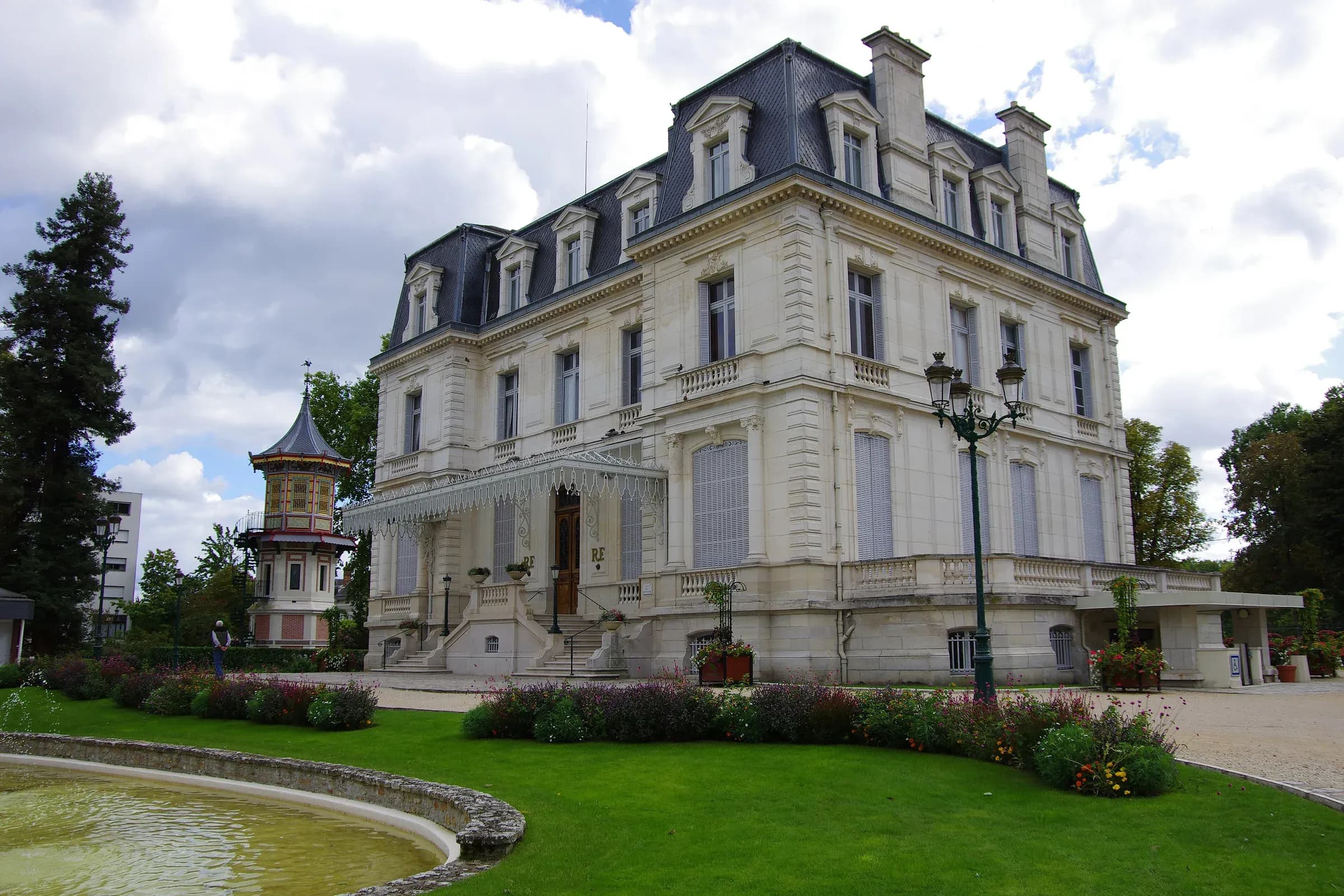 Hôtel de ville de Romorantin-Lanthenay et son jardin, sous un ciel de nuages blancs