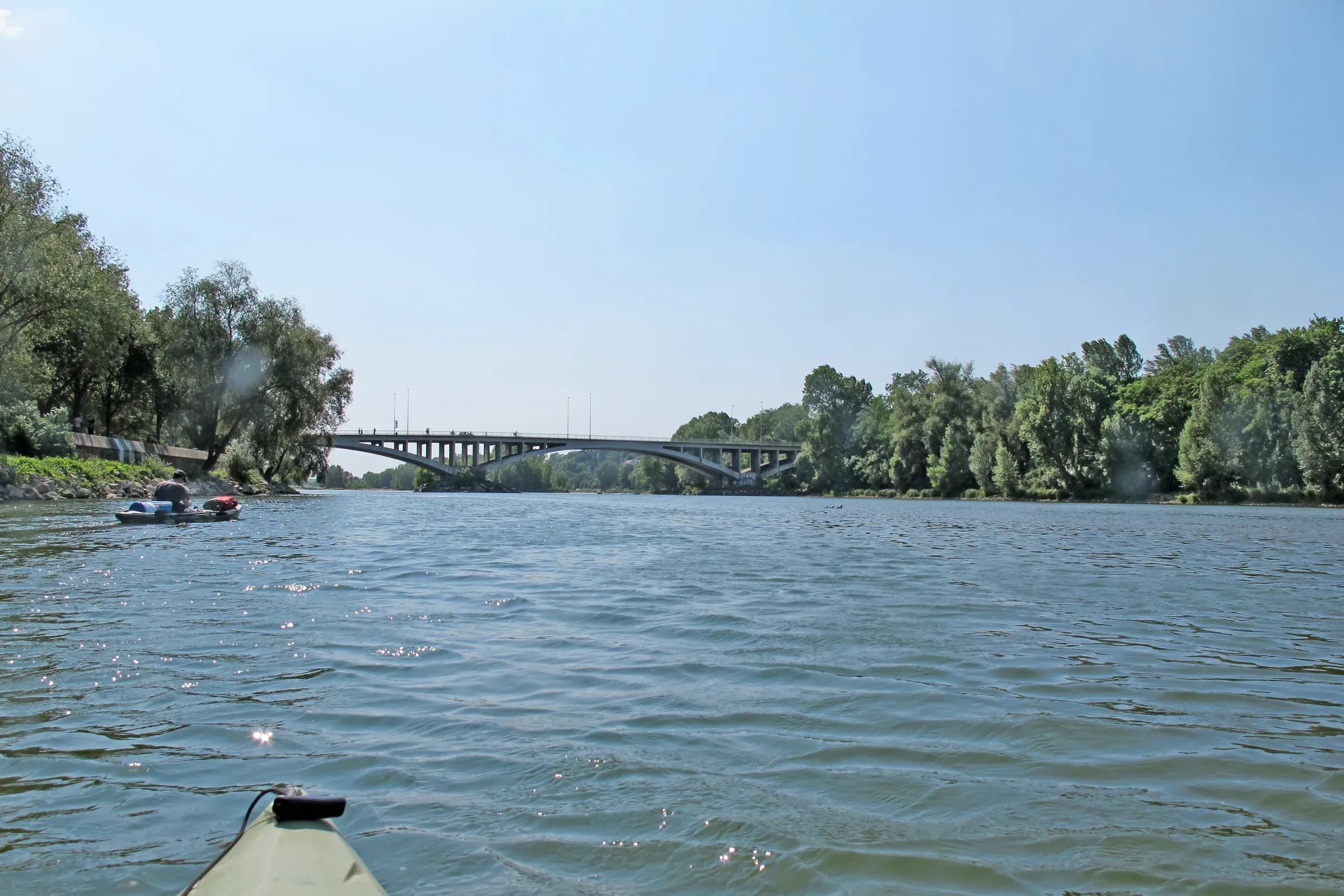 La Loire vue depuis un kayak, îles boisées et pont à l'horizon sous un ciel bleu