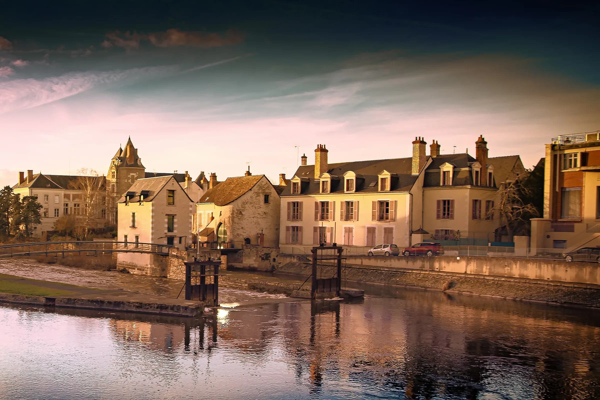 Moulins et maisons de Romorantin-Lanthenay au bord de la Sauldre, dorés par le soleil couchant