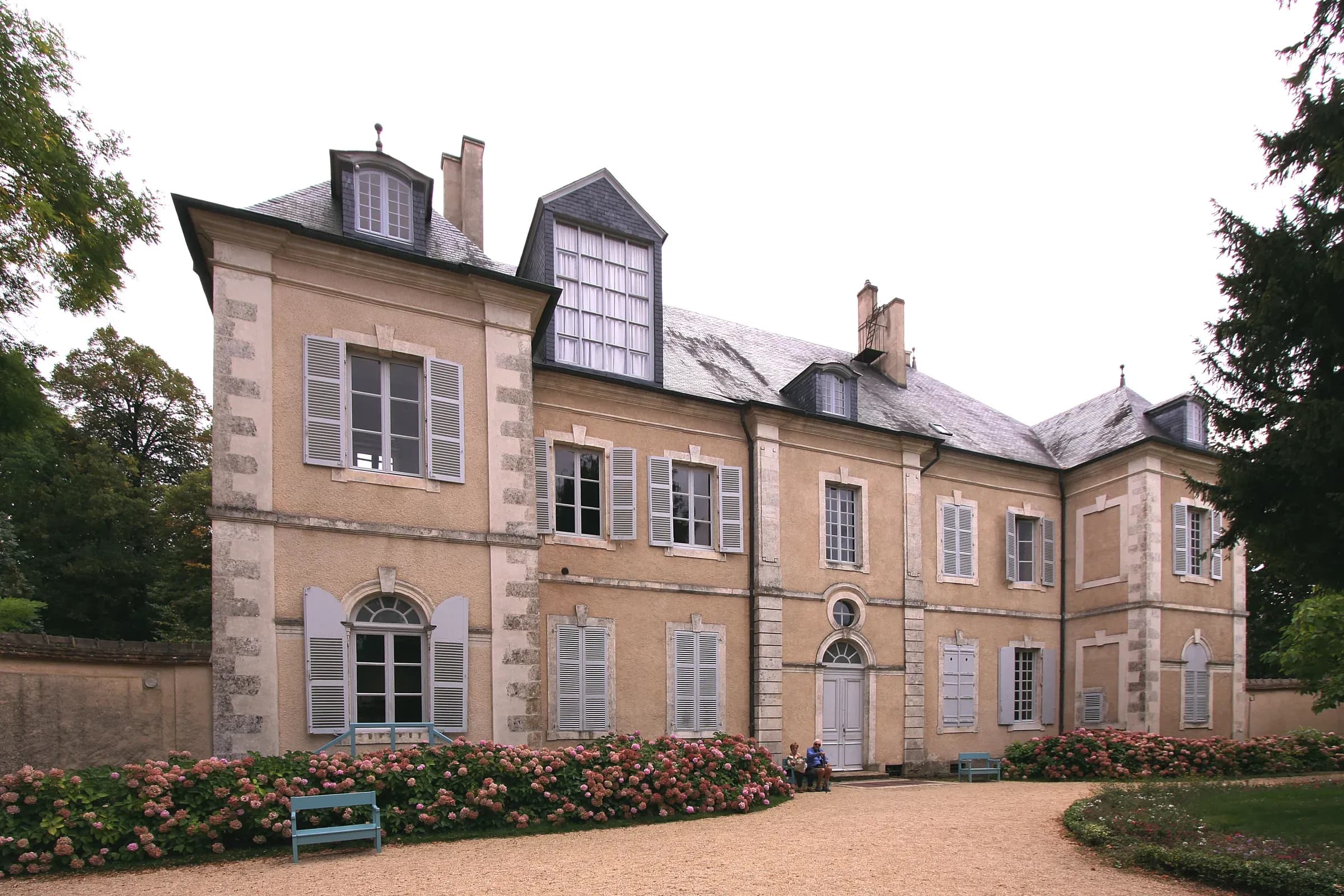 Façade de la maison de George Sand à Nohant, volets gris et massifs d'hortensias
