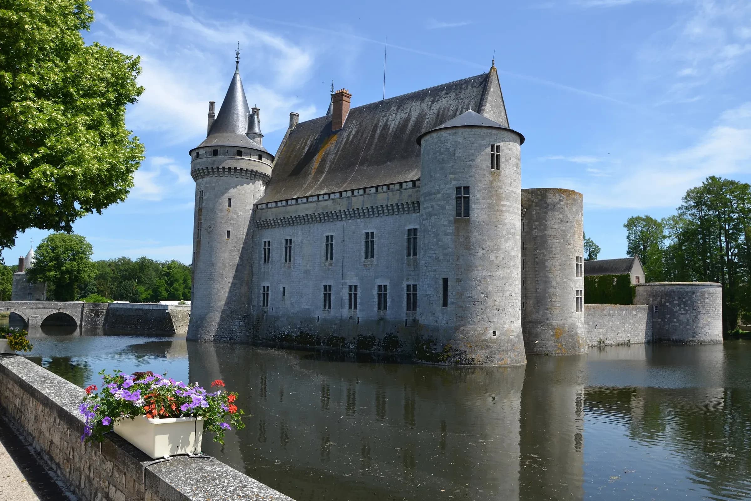 Château de Sully-sur-Loire, ses tours rondes et ses douves en eau sous un ciel bleu